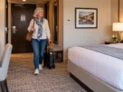 Mature traveler checking hotel room accessibility along the route beside the bed